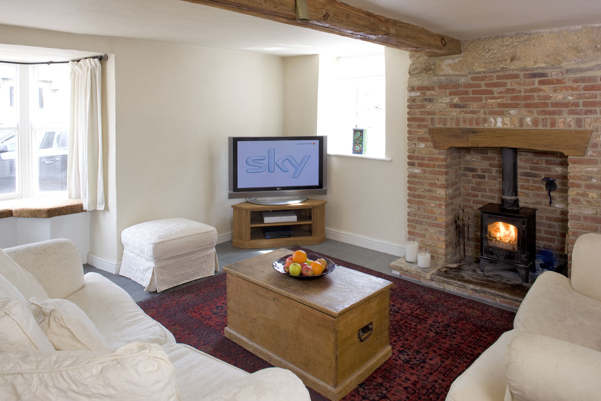 Comfy TV room with wood burning stove and satellite TV package